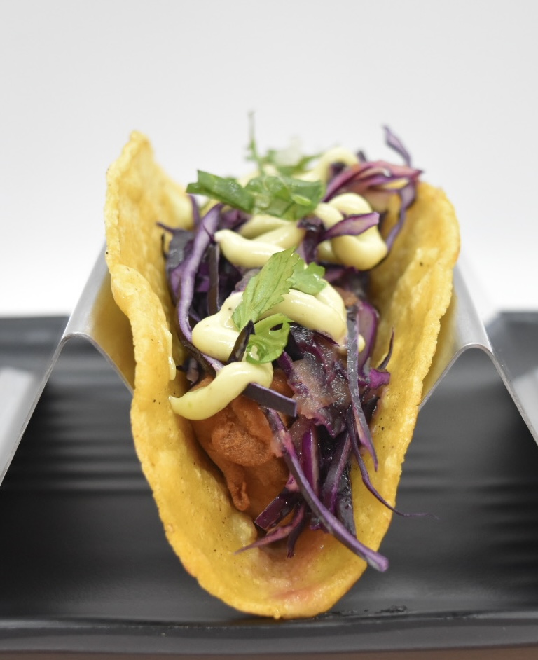 Crispy shrimp taco with purple slaw and avocado crema