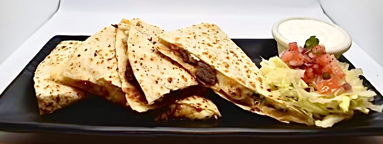 Grilled steak quesadilla wedges with pico de gallo and sour cream